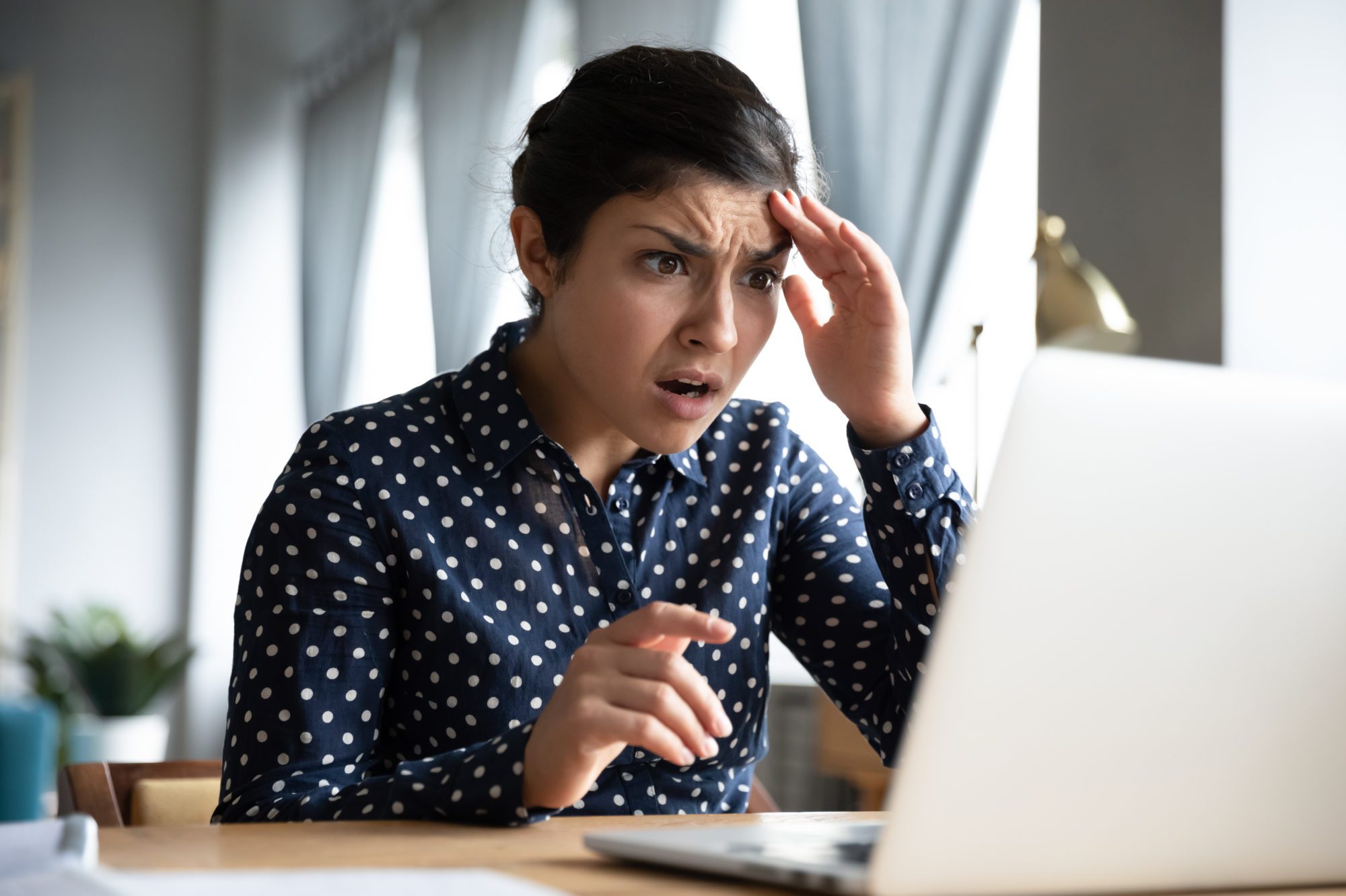 Shocked girl look at laptop computer screen at home office