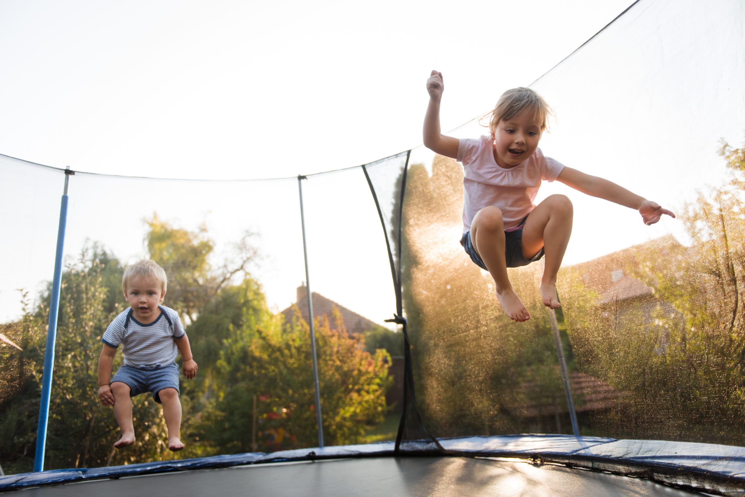 backyard summer safety kids jumping on trampoline